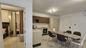 A modern kitchen with a dining area, a built-in oven, and a small island. - Cozy Modern two Bdr Place Sliema Ferry Tigne Point (Sliema)