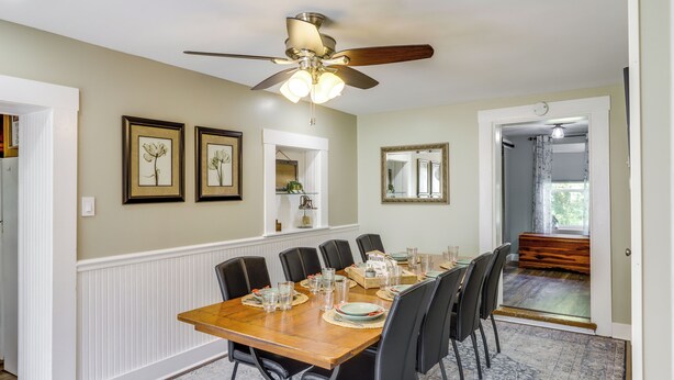 A dining area with a wooden table set for six, surrounded by black chairs. A ceiling fan with lights is above the table. - 'grandma Kellys' Southeast Indiana Farmhouse! (Cedar Grove)