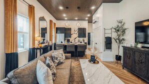 Un salon moderne avec un canapé, une table basse et un coin repas.