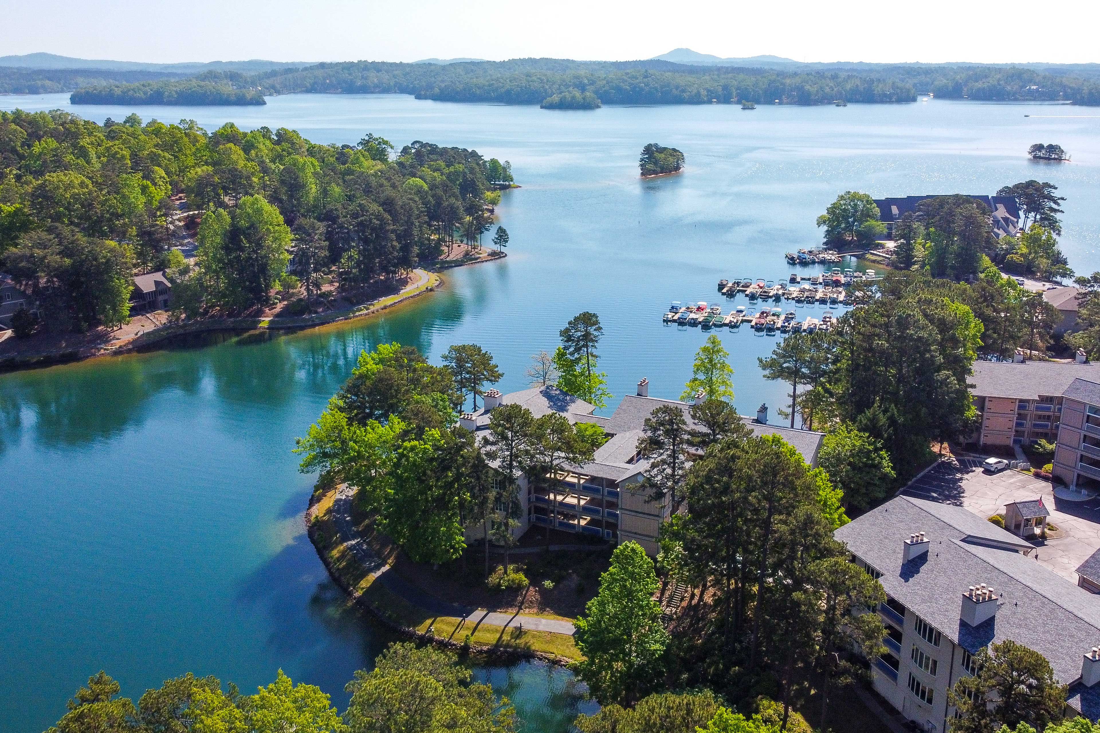 A lakeside property with a marina, multiple buildings, and surrounding greenery.