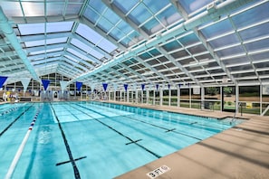 En inomhuspool med tydligt markerade banor, ett tak som skyddar mot väder och vind samt en sittplats.