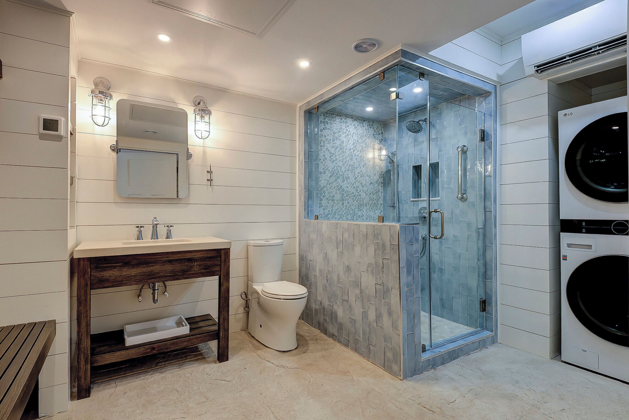 A modern bathroom with a glass-enclosed shower, a sink with a wooden vanity, and a toilet.