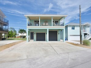Una casa a due piani con un balcone, un garage e un vialetto.