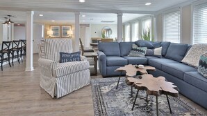 A living room with a striped armchair, a blue sectional sofa, and a patterned rug. - The Clubhouse Murrells Inlet (Murrells Inlet)