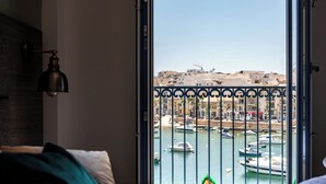 Un dormitorio con vistas a un puerto deportivo a través de una puerta abierta.