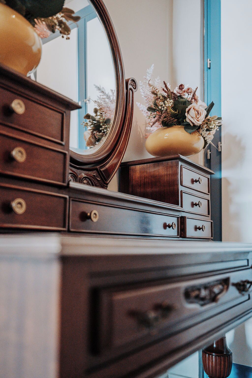 Una cassettiera in legno con diversi cassetti e uno specchio.