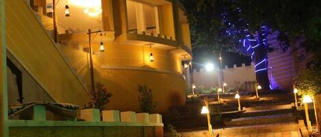 Vista frontal de la propiedad por la tarde o noche