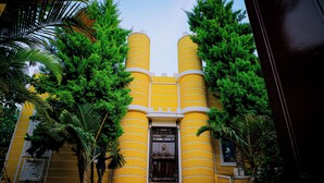 Un edificio amarillo con una entrada central flanqueada por dos estructuras cilíndricas.