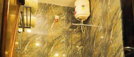 A bathroom with a marble wall, a toilet, a shower, and a towel rack.