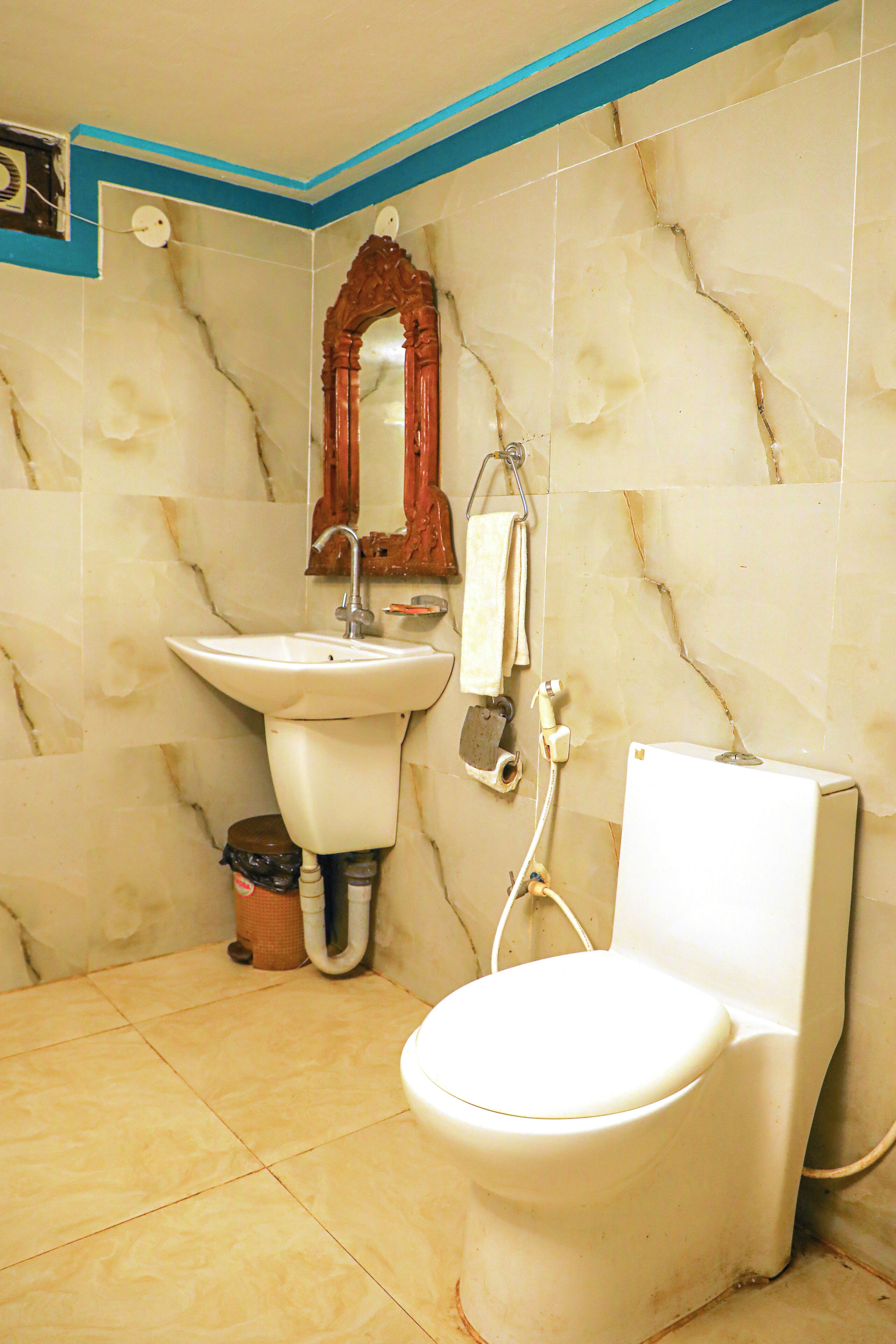 A bathroom with a toilet, sink, and mirror.