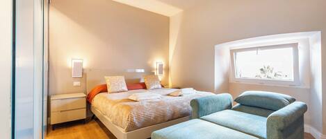 Ein modernes Schlafzimmer mit Bett, Nachttischen und einem Fenster.