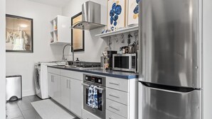 Una cocina moderna con electrodomésticos de acero inoxidable, horno empotrado y microondas.