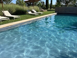 Ein Pool mit Liegestühlen und einer Holzterrasse.