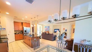 A spacious living area with a kitchen, dining area, and a TV. - 4/3 Canal Front Condo, Private Pool, Dock (Longboat Key)