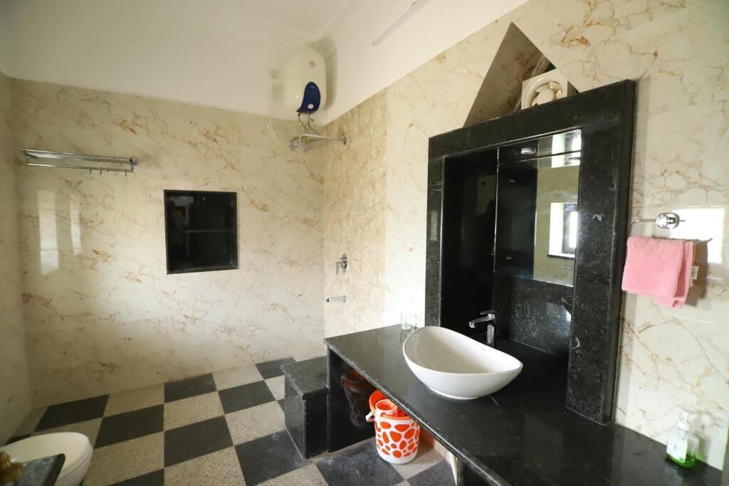 A bathroom with a checkered floor, a white sink, a black vanity, a mirror, and a towel rack.