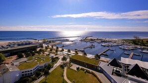 Un puerto deportivo con barcos, un puente y edificios con tejados verdes.
