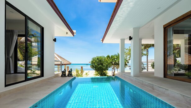 Una piscina interior moderna con vistas despejadas a la playa y al océano.