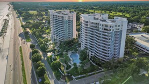 A high-rise hotel with multiple balconies, a swimming pool, and a well-maintained garden. - Legacy Tower II 107 | Charming Ground-Floor Deluxe Unit! (Gulfport)