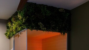 Una sala de sauna con un banco y un balde.