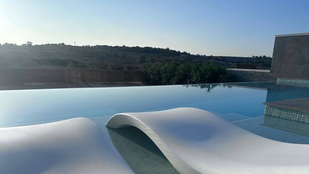 Una piscina moderna con un diseño original de borde ondulado.