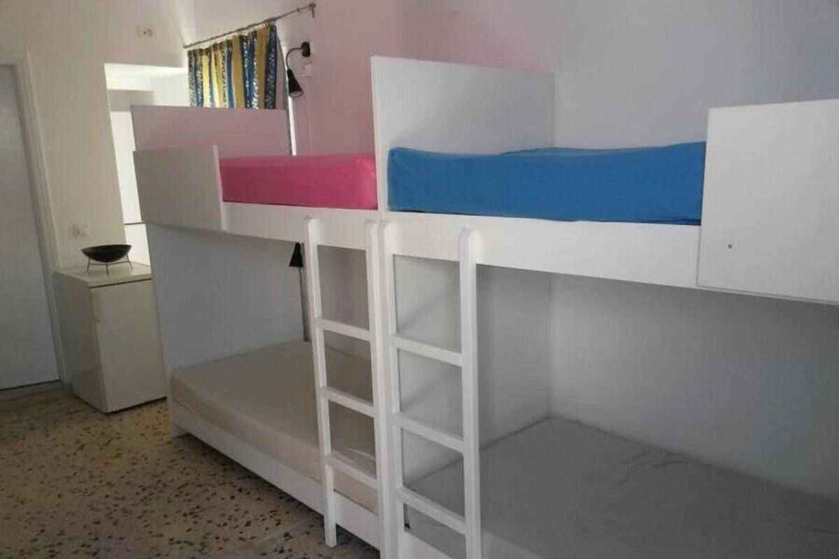 Habitación con literas, un escritorio pequeño y una silla.