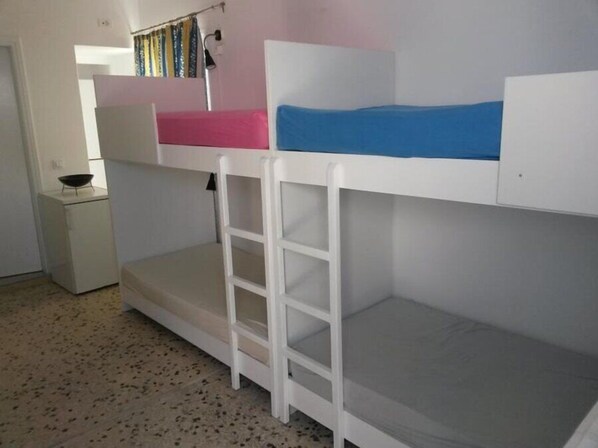 Une chambre avec un lit superposé, un petit bureau et une chaise.