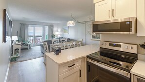 A modern kitchen with white cabinetry, a built-in microwave, and a stainless steel oven. - Condo in Duck with Ocean Views, Community Amenities (Duck)