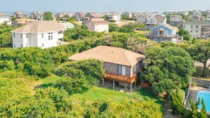 A residential area with houses surrounded by greenery. - Sun Realty pet-friendly oceanside home just 500' to the beach (Duck)