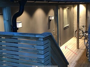 A wooden staircase leading to a room with a bicycle parked outside. - Arctic Escape Studio in Tromso (Tromsø)