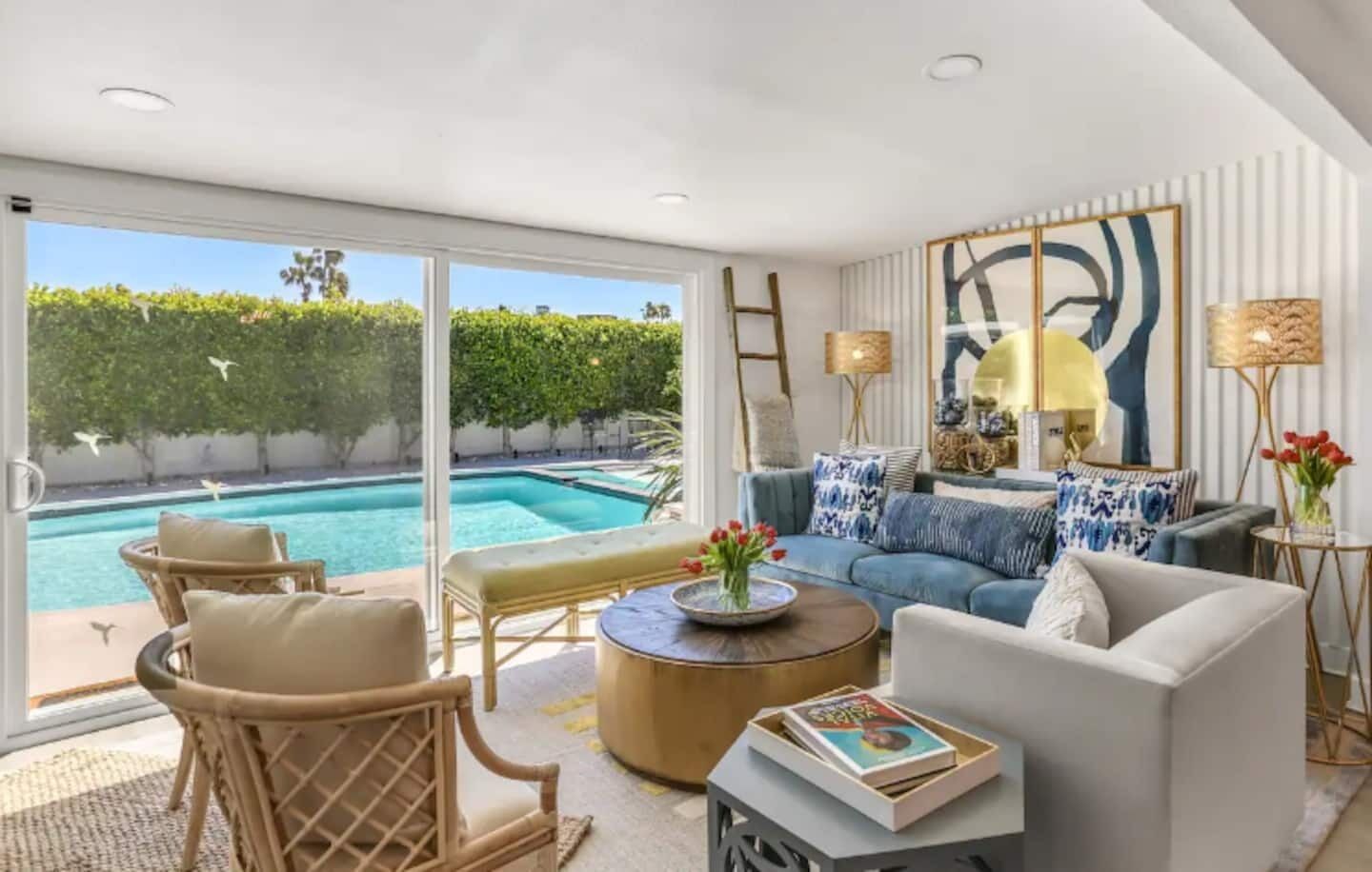 A modern living room with a pool view, comfortable seating, and decorative elements.