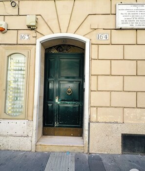 A building entrance with a green door, numbered 163 and 164, and a plaque above. - Elegant apartment in the heart of Rome - Spanish Steps (Roma)