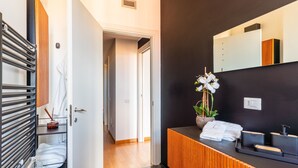 A modern bathroom with a black wall, a wooden vanity, a mirror, and a towel rack. - Fiftyfive-one Zuretti (Milano)