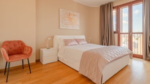 A bedroom with a bed, a nightstand, a chair, and a window with curtains. - Fiftyfive-one Zuretti (Milano)