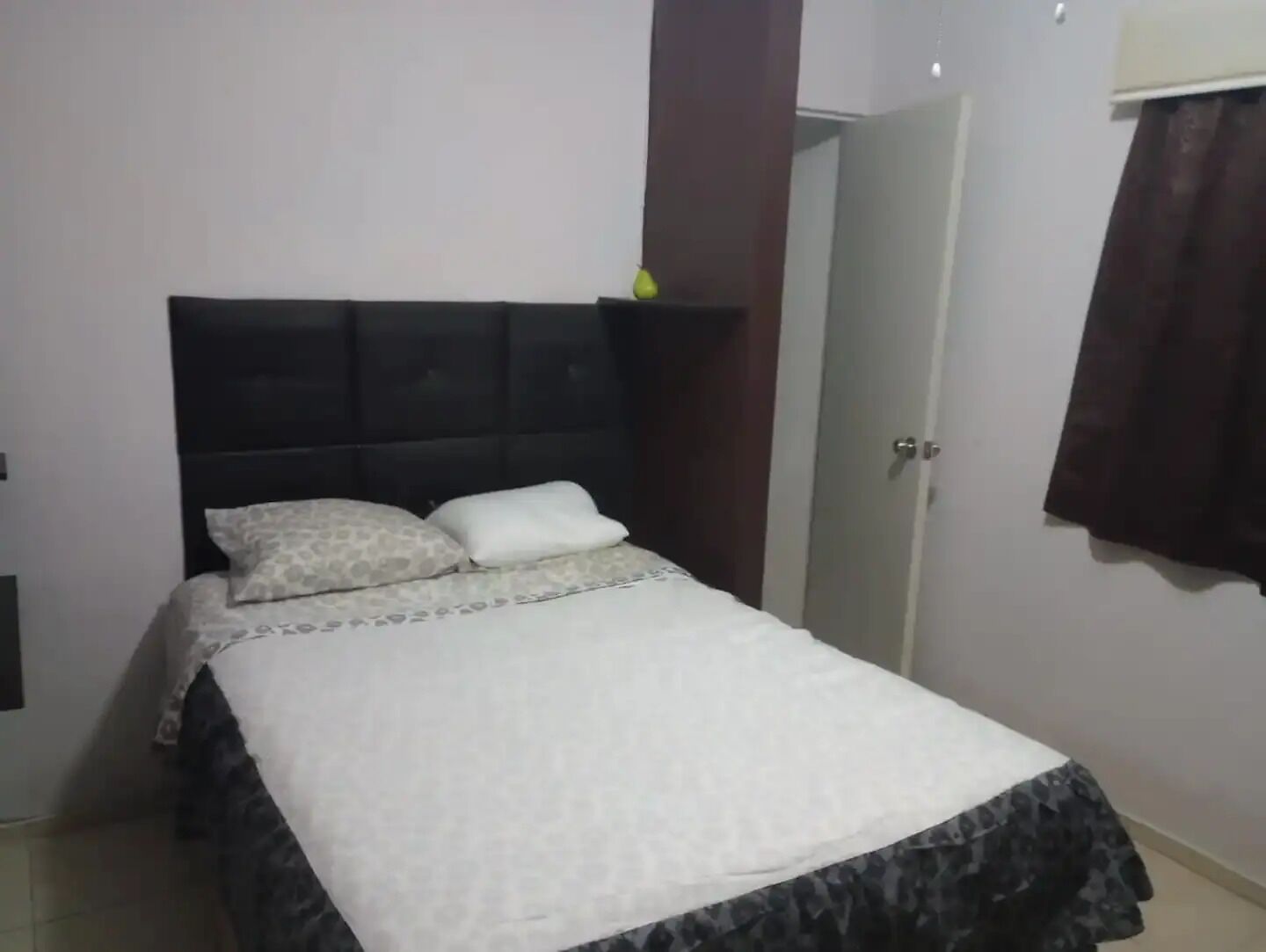 A bedroom with a bed, a wardrobe, and a door.