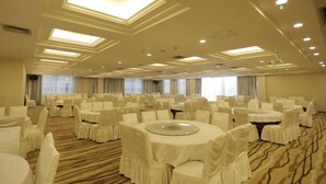 A large banquet hall with round tables and chairs, recessed lighting, and a carpeted floor. - Vienna International Hotel (Mount Emei Crystal Plaza Hotel) (Emeishan City)