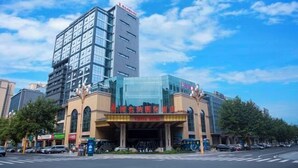 A modern hotel with a glass facade and a prominent entrance. - Vienna International Hotel (Mount Emei Crystal Plaza Hotel) (Emeishan City)