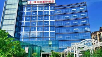 A modern building with a glass facade, multiple floors, and a sign indicating it is a hotel.