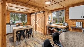 Un interior de madera con comedor, cocina y ventanas amplias.