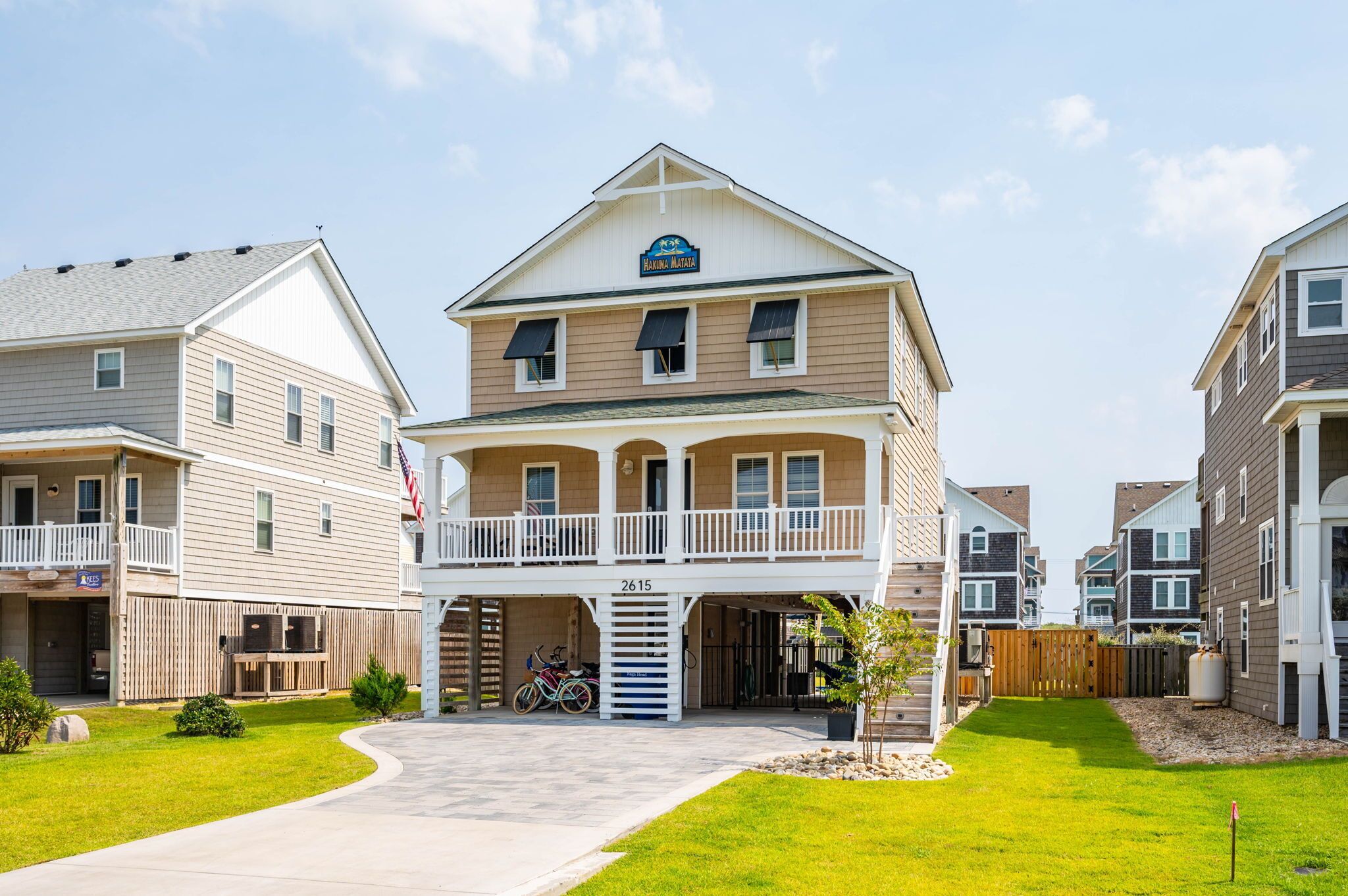 A two-story residential building with a balcony, a garage, and a well-maintained lawn.