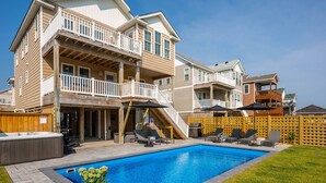 Et toetagers hus med en baghave, swimmingpool, jacuzzi og en træterrasse.