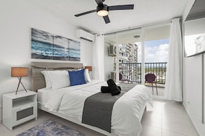 Relax in a spacious room with a large bed, city view, and modern amenities.