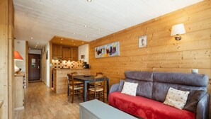 A cozy cabin interior with a dining area, a sofa, and a kitchen.