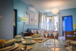 Une table à manger avec des verres à vin, des assiettes et des couverts.