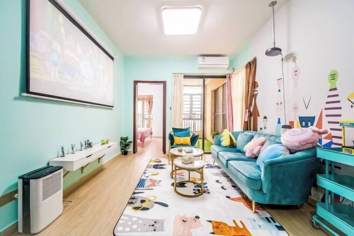 Een moderne woonkamer met een blauwgroene bank, een salontafel en een kleurrijk vloerkleed.
