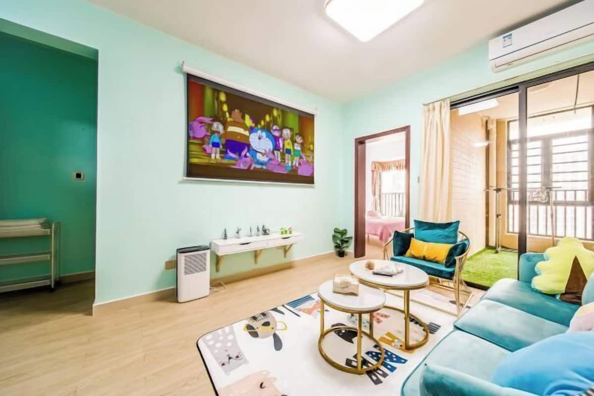 Een woonkamer met een bank, een salontafel, een schilderij aan de muur en een raam.