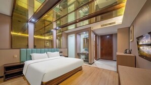 Une chambre d’hôtel moderne avec un grand lit, un mur en verre et un plancher en bois.