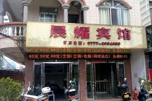 A hotel sign with a contact number and a list of room rates.