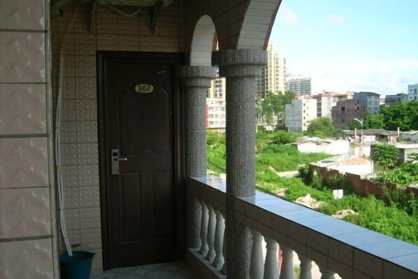 A balcony with a stone balustrade overlooking a residential area.