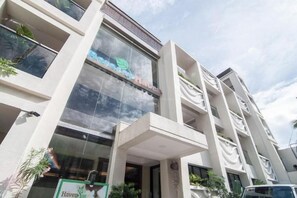 Un hôtel à plusieurs étages au design moderne, doté de balcons et de grandes fenêtres.