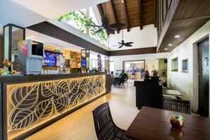 Un intérieur moderne comprenant un comptoir d’accueil, un espace détente et un bar.